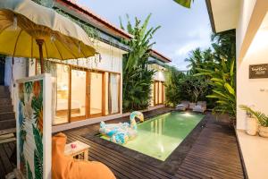 a house with a swimming pool and an umbrella at Kemiri Villa Lembongan in Nusa Lembongan
