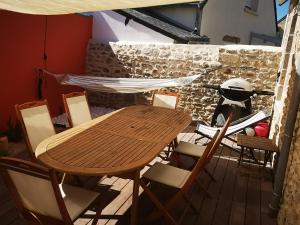 Une table et des chaises en bois sont disponibles sur la terrasse. dans l'établissement LA BICOQUE A TITI, au Croisic