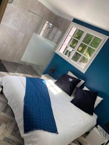1 dormitorio con 1 cama grande y pared azul en Au P'ti Parc de Madon, en Candé-sur-Beuvron
