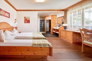 a bedroom with a bed and a bathroom with a sink at Alpine Resort Goies Superior in Ladis