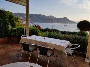 a table and chairs on a patio with a view of the ocean at Hôtel de Charme Brise Marine in Saint-Jean-Cap-Ferrat