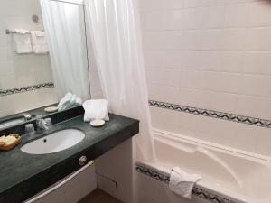 a bathroom with a sink and a bath tub at Hôtel de Charme Brise Marine in Saint-Jean-Cap-Ferrat