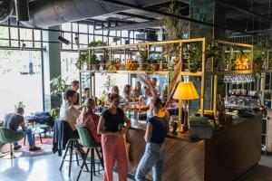 people are sitting at a bar in a restaurant at Conscious Hotel Amsterdam City - The Tire Station in Amsterdam