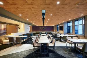 een eetkamer met tafels, stoelen en ramen bij Mercure Yinchuan Xinhua in Yinchuan