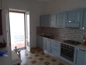 a kitchen with blue cabinets and a large window at GIARDINO SUL MARE in Amalfi