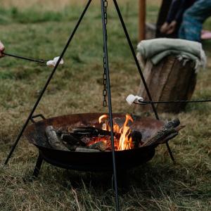 a grill with tongs and a fire at Abbeyfield Horsebox Glamping in Morpeth