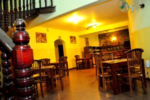 a dining room with wooden tables and chairs at Milano Tourist Rest in Anuradhapura