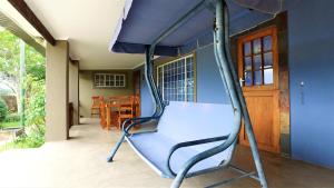 a blue porch swing in a room with a house at Blyde Mountain Country House in Hoedspruit