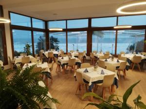 a restaurant with tables and chairs and large windows at Hotel Llorca in Platja de l’Almadrava