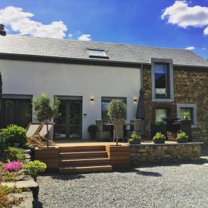 a house with a deck and a patio at L'Hoursinne in Érezée