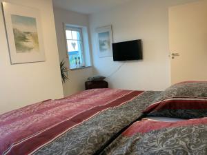 a bedroom with a bed and a flat screen tv at Ferienoberwohnung in Villa Pesca in Cloppenburg