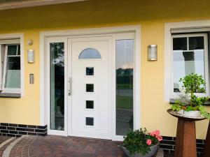 a white door on a house with a patio at Ferienoberwohnung in Villa Pesca in Cloppenburg