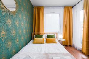 una camera da letto con letto, cuscini gialli e specchio di Sleepway Apartments -Garbary 95-101D a Poznań