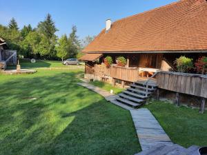 a house with a wooden staircase leading to a yard at Rustic home Mia in Duga Resa