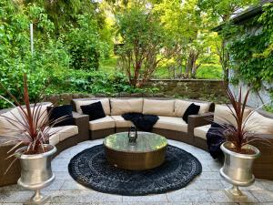 a patio with a couch and a coffee table at VILLA ADELEes BOUTIQUE HOTEL in Alsfeld
