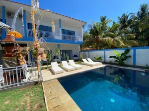 a swimming pool in front of a house at Kura Kura Divers Lodge in Amed