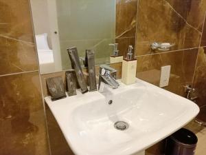 a white sink in a bathroom with a mirror at La Maison Royale South C in Nairobi