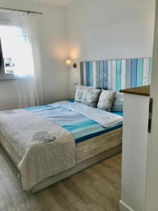 SK Apartments -Apartment mit 2 Schlafzimmern في روست: غرفة نوم بسرير كبير مع اللوح الخشبي