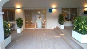a lobby with two potted plants in front of a building at Hotel Llorca in Platja de l’Almadrava