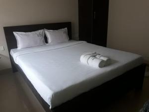 - un lit blanc avec une caméra au-dessus dans l'établissement La Villa Beach Paradise, à Mahabalipuram