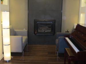 a living room with a piano and a couch at Hotel Llorca in Platja de l’Almadrava