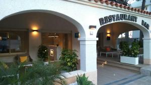 an entrance to a restaurant with plants in a building at Hotel Llorca in Platja de l’Almadrava