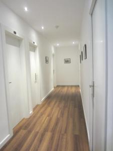 an empty hallway with white walls and wood floors at Hotel Llorca in Platja de l’Almadrava