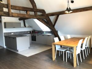 een keuken en eetkamer met een houten tafel en stoelen bij POSTRELAIS ARDENNES "Belle-Vue" in Burg-Reuland