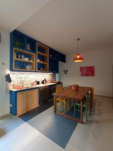uma cozinha com armários azuis e uma mesa de madeira em Silibardi em Agrigento