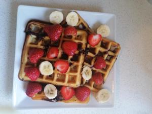 a waffle with strawberries and bananas on a plate at No 12 B&B in Dungarvan