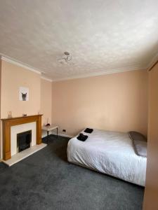 sypialnia z łóżkiem i kominkiem w obiekcie Radanks House - Fratton w mieście Portsmouth
