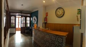 un bar en un restaurante con un reloj en la pared en Hostal San Miguel, en Nerja