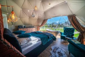 sypialnia w namiocie z łóżkiem i krzesłem w obiekcie Mountain Glamp & Gorąca Balia w Zakopanem