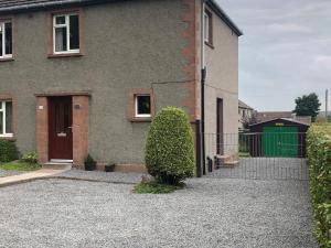 a house with a bush in front of it at Dallaire House in Banchory