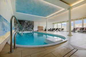 a swimming pool in a room with a swimming pool at Ferienwohnungen Ortlerblick in Malles Venosta