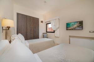 Postel nebo postele na pokoji v ubytování Hotel Cala Lunga
