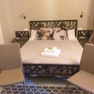 a bedroom with a bed with a engagement ring and two chairs at Casa D'amore in Riomaggiore