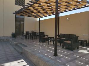 استراحة واحة ڤاي في جدة: فناء بطاولات وكراسي تحت سقف