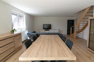 une salle de conférence avec une table et des chaises en bois dans l'établissement Brenda's Stay - Relax Appartement, à Bredene