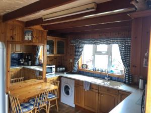 a kitchen with wooden cabinets and a washer and dryer at Dallaire House in Banchory