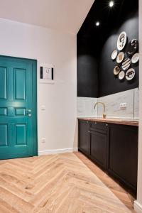 a kitchen with a green door and a counter at Apartman Otokar in Osijek