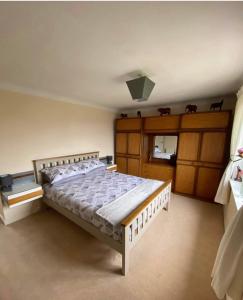 a bedroom with a large bed with wooden cabinets at Dallaire House in Banchory