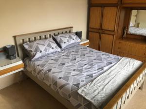 a bedroom with a bed with a gray and white comforter at Dallaire House in Banchory