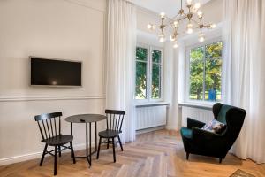 a living room with a table and chairs and a tv at Apartman Otokar in Osijek