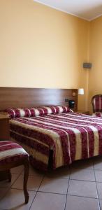 a bedroom with a large bed and two chairs at Hotel Scrivano in Randazzo