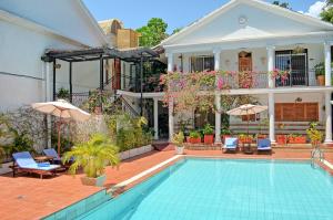 a house with a swimming pool in front of a house at Sovereign Hotel in Kisumu