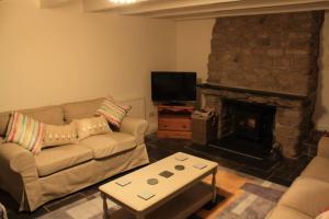 a living room with a couch and a fireplace at Bojewyan Cottage, Sandy Beaches and Great walking in Penzance