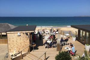 a group of people sitting at tables on the beach at Bojewyan Cottage, Sandy Beaches and Great walking in Penzance +22 photos