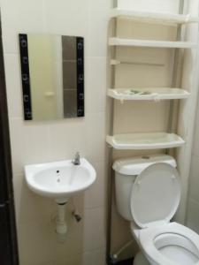 La salle de bains est pourvue de toilettes et d'un lavabo. dans l'établissement Homestay Idaman 2, à Bukit Kayu Hitam