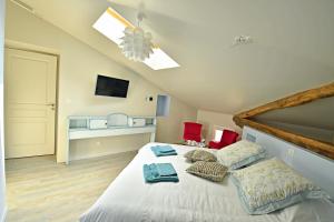 1 dormitorio con 1 cama blanca grande con almohadas rojas en Ô gré des sens, en Coufouleux